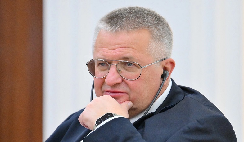 Политический деятель Оверчук на фоне армянского флага, обсуждая выборы в Нор-Норкском районе Еревана