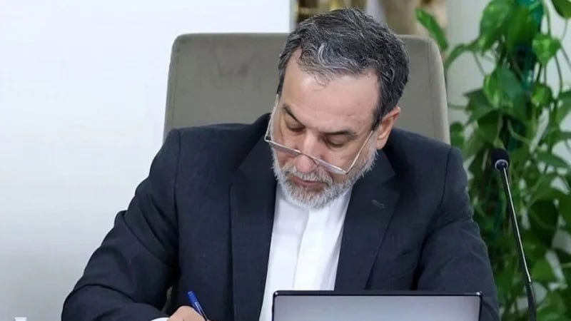 Министр иностранных дел Ирана Аббас Аракчи в официальной обстановке, на фоне флага Ирана